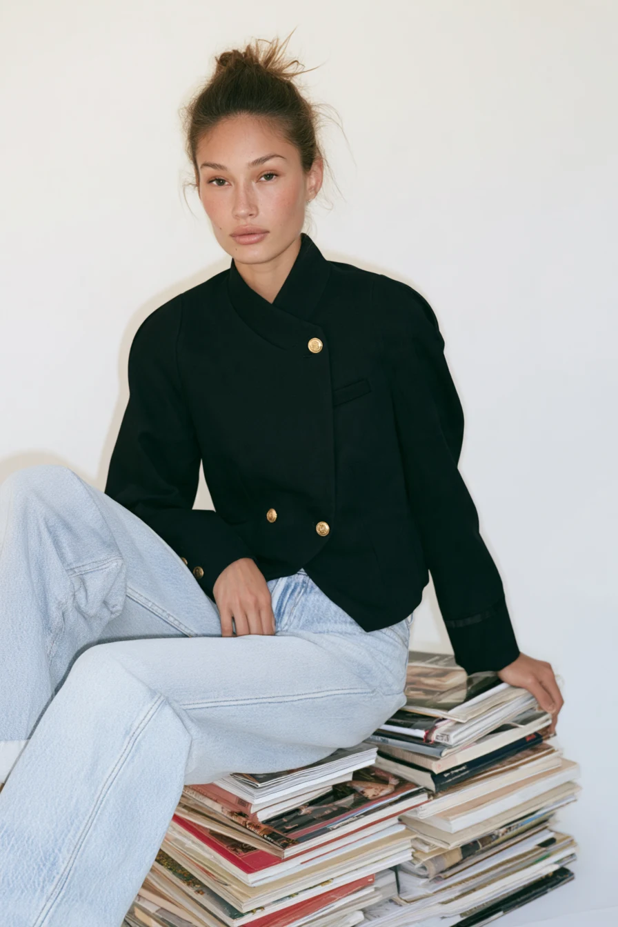 Look 1: Model sitzt auf Magazinen